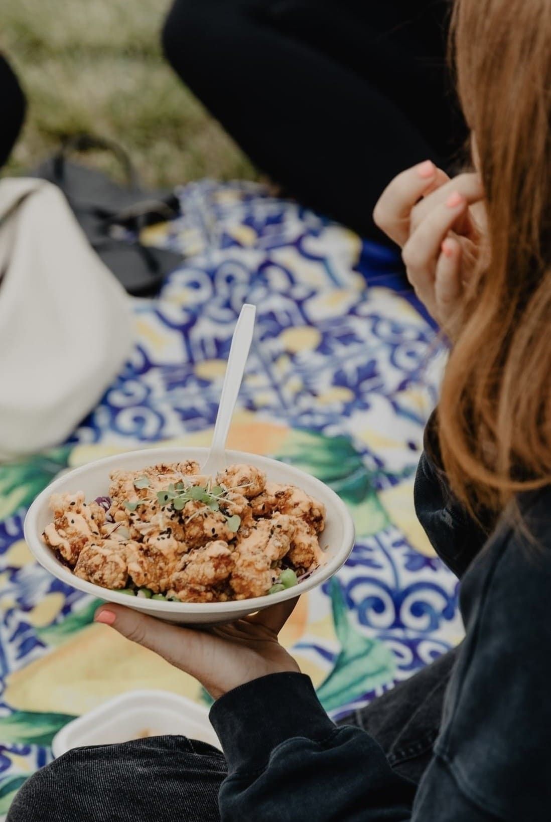 A guest holding a fresh Ichiban chicken bowl at an outdoor event